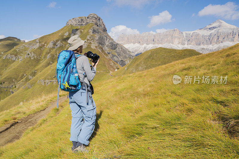 在意大利北部Dolomites的Viel dal Pan小径徒步旅行时，一名老妇人正在欣赏萨斯·德·卡佩洛峰的美丽景色。